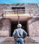 Construction worker inspecting a building construction site and reviewing project progress